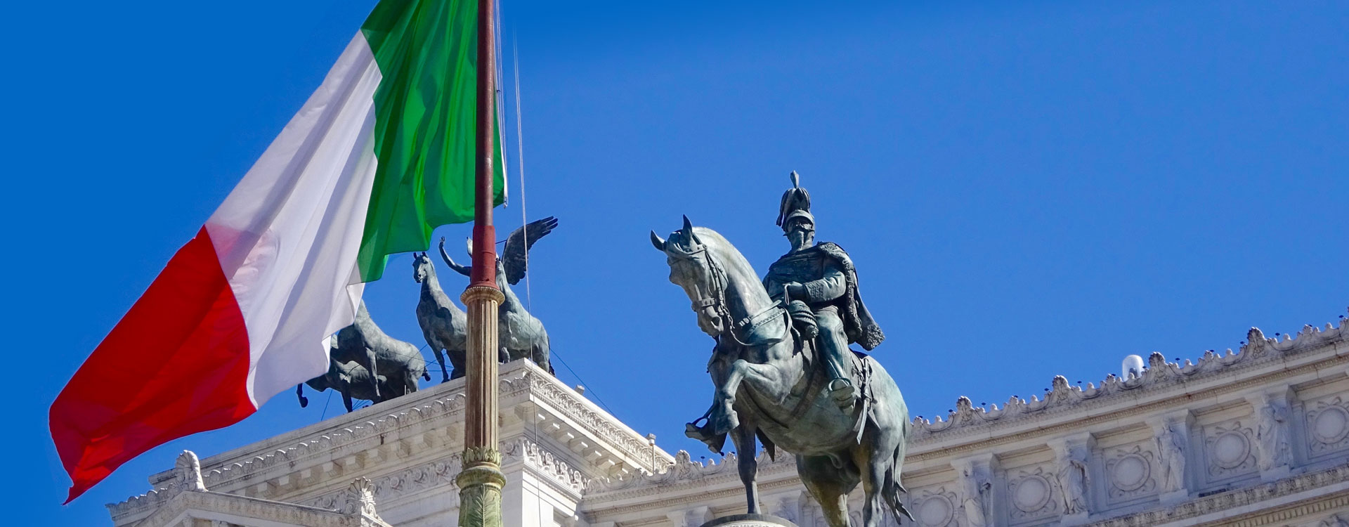 statue of an Italian king near an Italian flag