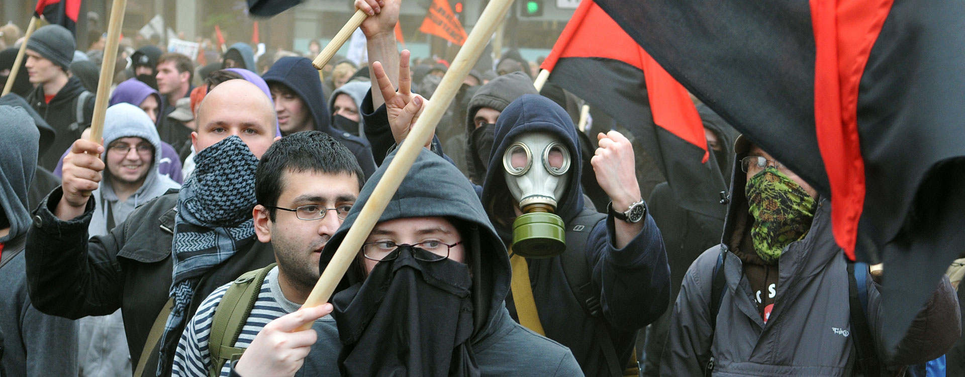 angry mob of protesters one wearing a gas mask