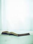 Open bible on a table white background