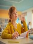 A girl in school, raising her hand