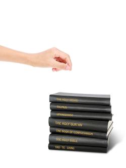 Different religious texts with hand which to choose
