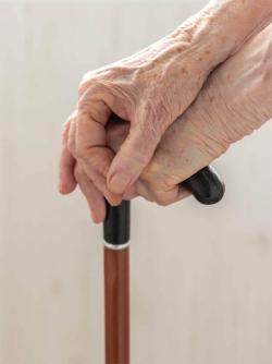 Elderly hands on a cane