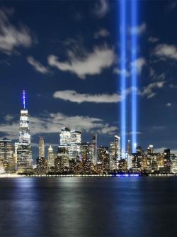 World Trade Center memorial lights with cityscape