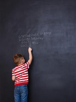 Child writing on a chalkboard education principles