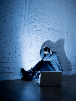 Girl holding her head in front of a laptop