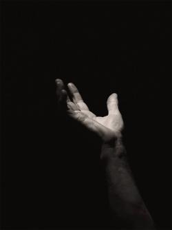 Hand reaching for help from the darkness