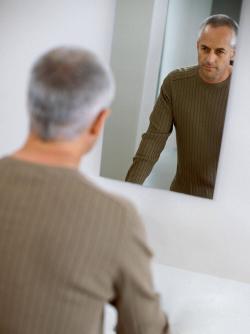 Man looking in a mirror contemplatively