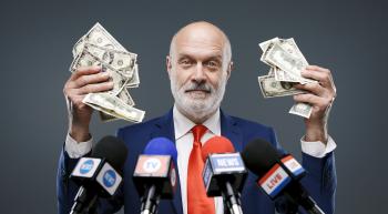 politician standing in front of reporters microphones and holding wads of cash