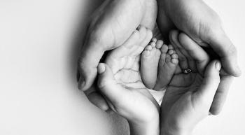 couple's hands holding baby feet