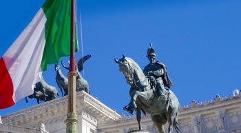 statue of an Italian king near an Italian flag