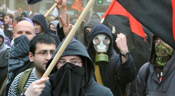 angry mob of protesters one wearing a gas mask