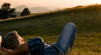 man relaxing in a peaceful field 