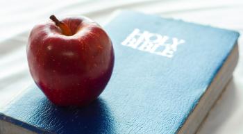 an apple placed on top of a Bible