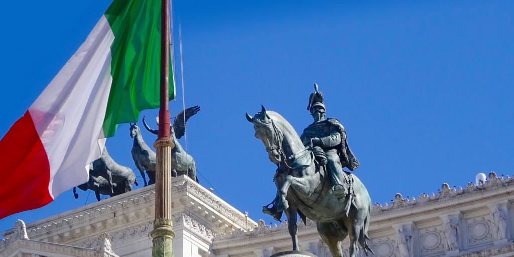 statue of an Italian king near an Italian flag