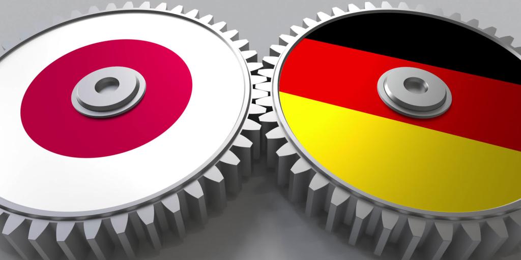 two gears meshed together, one depicting the Japanese flag the other the German flag