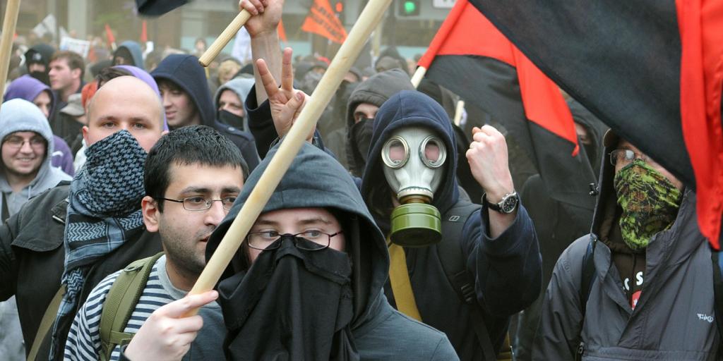 angry mob of protesters one wearing a gas mask