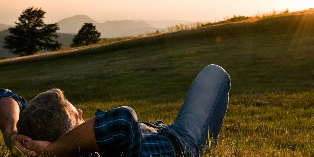 man relaxing in a peaceful field 