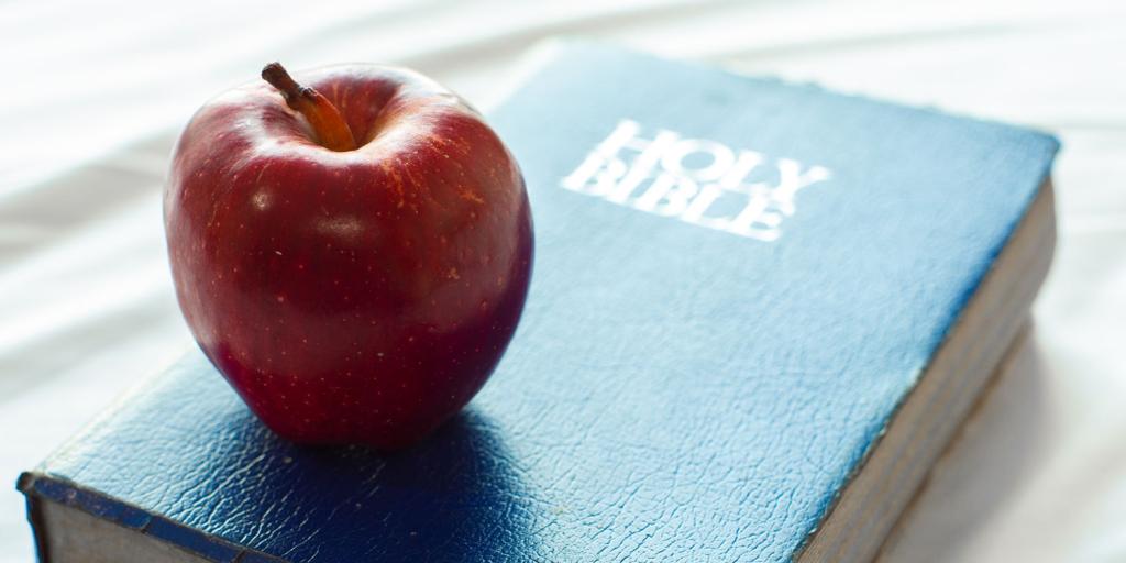 an apple placed on top of a Bible