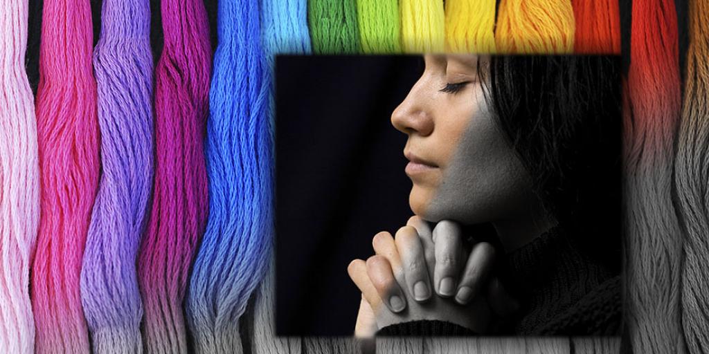 Woman praying, slowly turning from black and white into color, with stripes of vivid color in the background, fading from grey to rainbow shades.