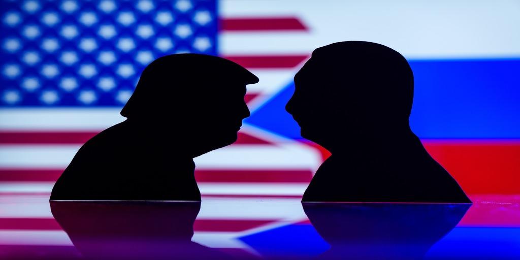 black silhouette cutouts of Donald Trump and Vladimir Putin facing each other, with the flags of the United States and Russia in the background