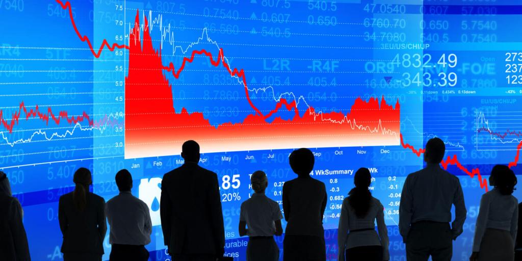 silhouettes of people watching a downward trending graph