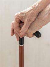 Elderly hands on a cane