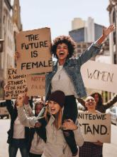 Women demonstrators holding future is female sign