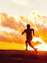 Woman running at sunset willpower concept