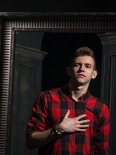 A young man talking to himself in front of a mirror