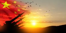 Chinese flag with missiles and sunrise with hills covered in trees or soldiers