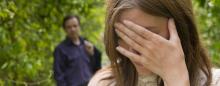Stressed out woman with hand over her face and a concerned man looking on