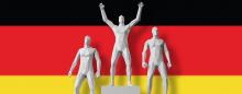 men on award podium in front of German flag