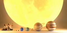 A model of the Sun, glowing above a row of planets made to scale. Two children sit to the side, pointing up in interest.