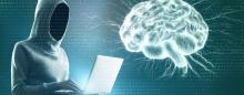 ominous hacker looking at laptop and a human brain