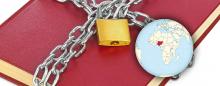 a Bible in chains next to a globe pointing out the country of Nigeria