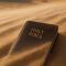 A Bible lying in the desert sand, partially obscured