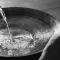water being poured into a large bowl for foot washing
